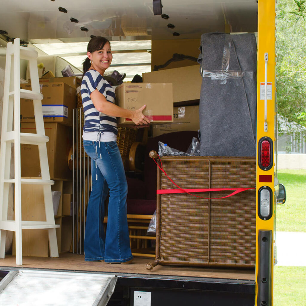 a woman packing boxes into a moving van