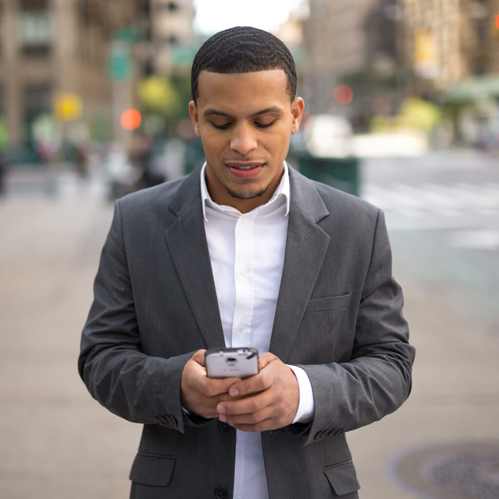 a professional young man on his phone along the streets of new york