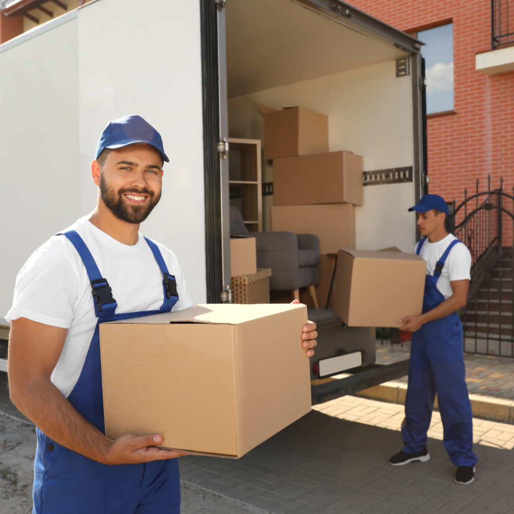Moving professionals smiling and loading boxes into truck