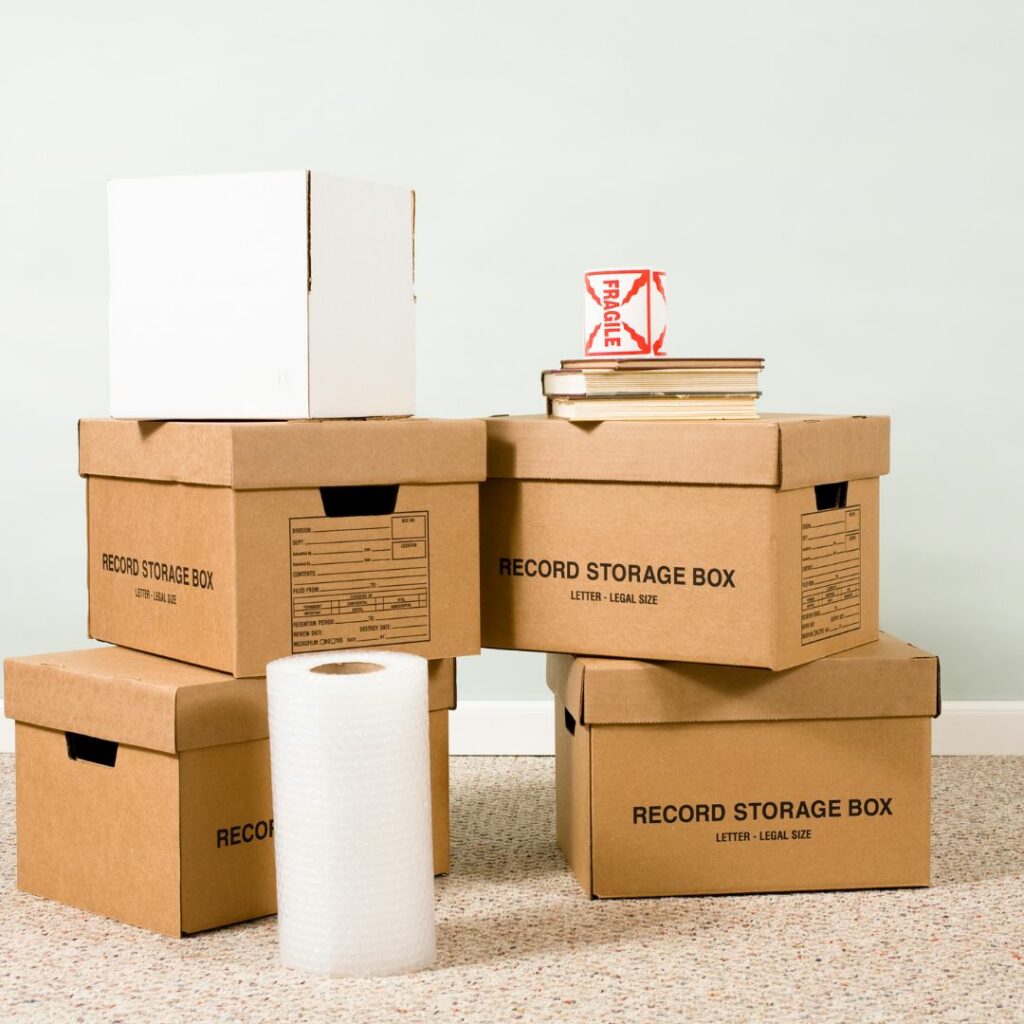 Packing supplies, including cardboard boxes, bubble wrap, and fragile tape
