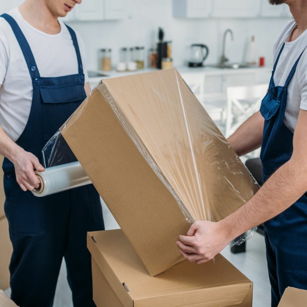 Movers wrapping boxes