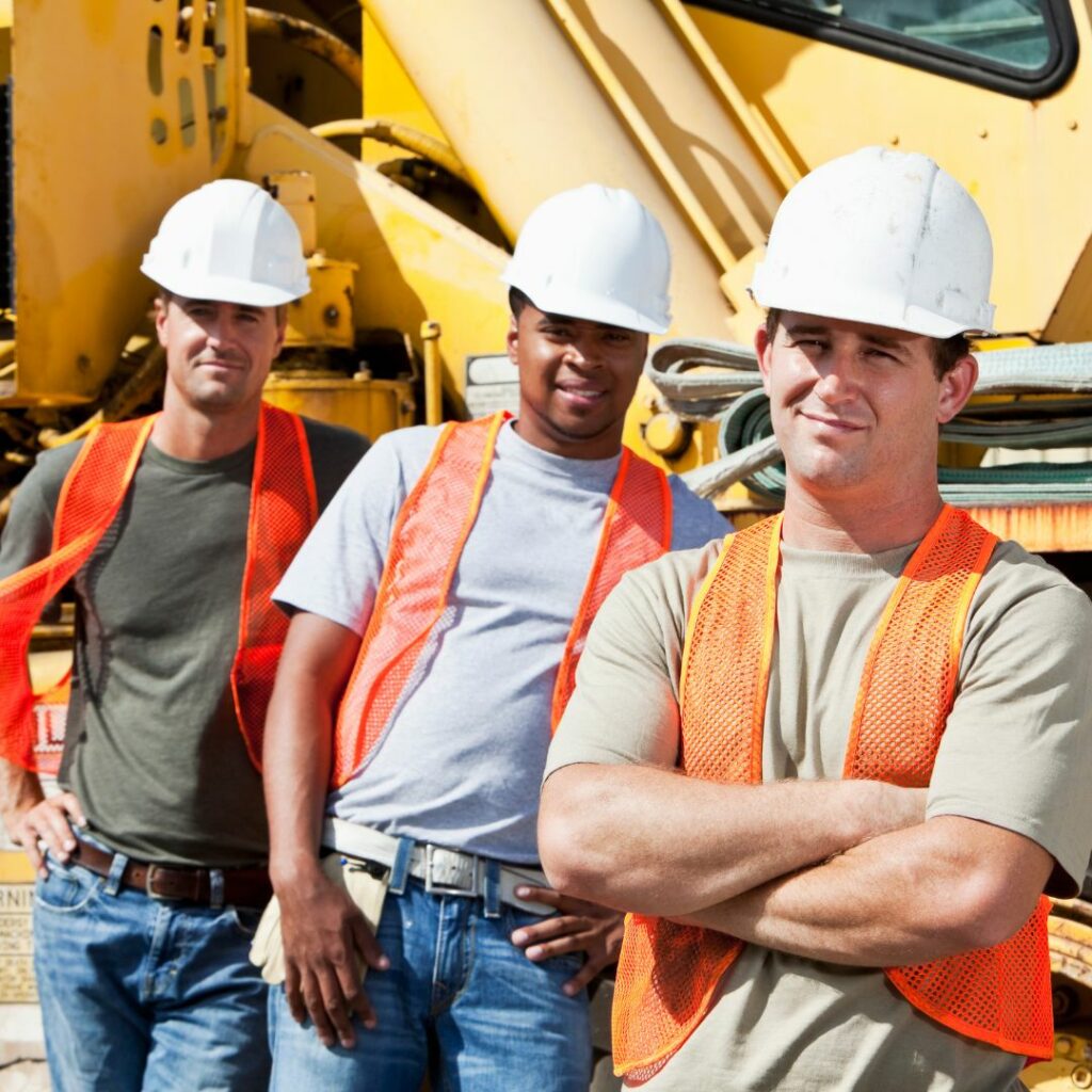 three construction workers with heavy machinery